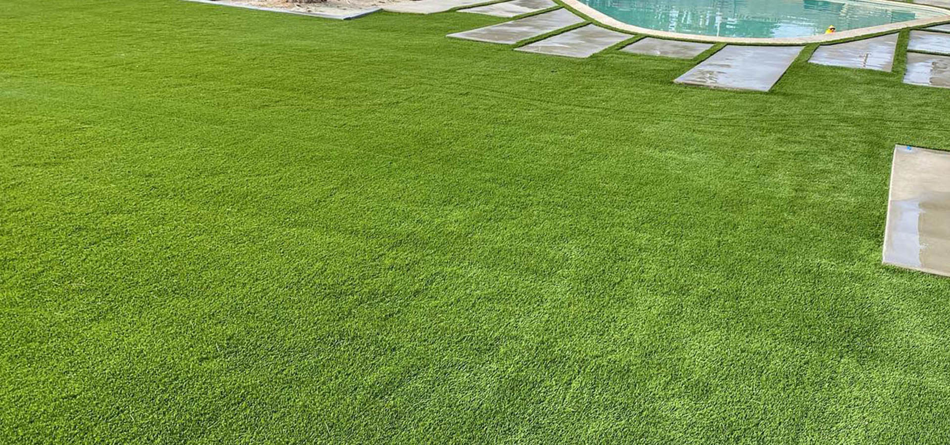 green grass with a pool and stonework